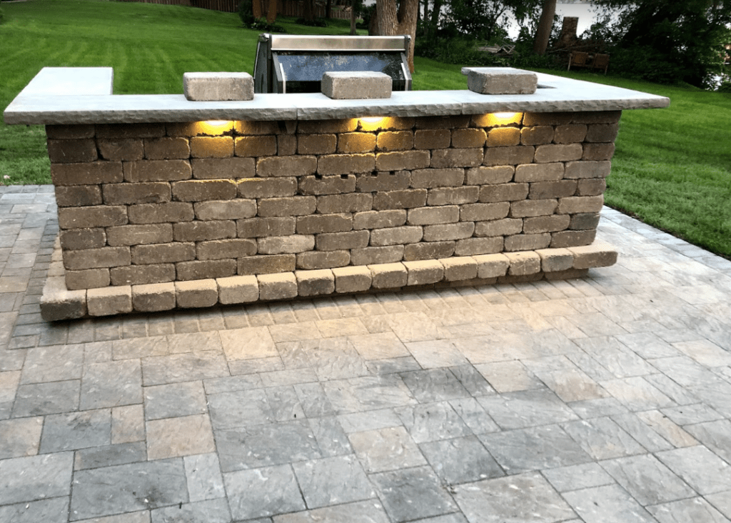 Outdoor kitchen with bar, grill & paver patio